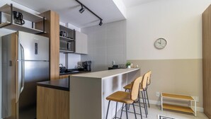 A modern kitchen with a built-in island, stainless steel appliances, and wooden accents. - Apartments Next to Ufsc - SVE (Florianópolis)