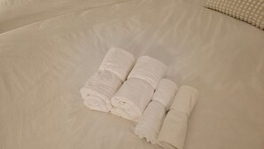 A neatly made bed with three rolled white towels placed on it. - A cozy accommodation in Nakano City, 3 stops from Shinjuku, for 4 people (Nakano City)