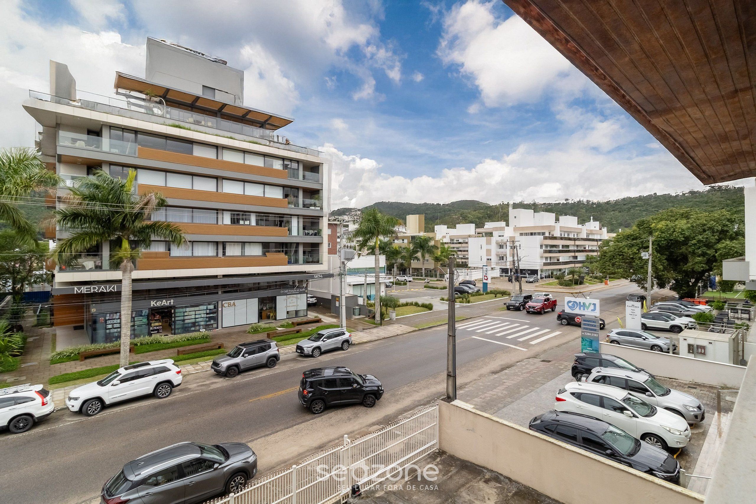 A multi-story building with a modern design, featuring a ground floor with commercial spaces and upper residential units.