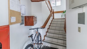 A staircase with wooden railings and a hand sanitizer dispenser mounted on the wall.