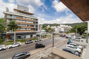 A multi-story building with a modern design, featuring a ground floor with commercial spaces and upper residential units. - Fully Equipped Apartments Just Minutes From Jurere Beach - CIE (Florianópolis)