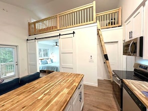 A compact kitchen with a wooden countertop, a built-in oven, and a microwave. - 120 & 122 Falkirk 2 Pet Friendly Beach Cottages (Fort Myers Beach)