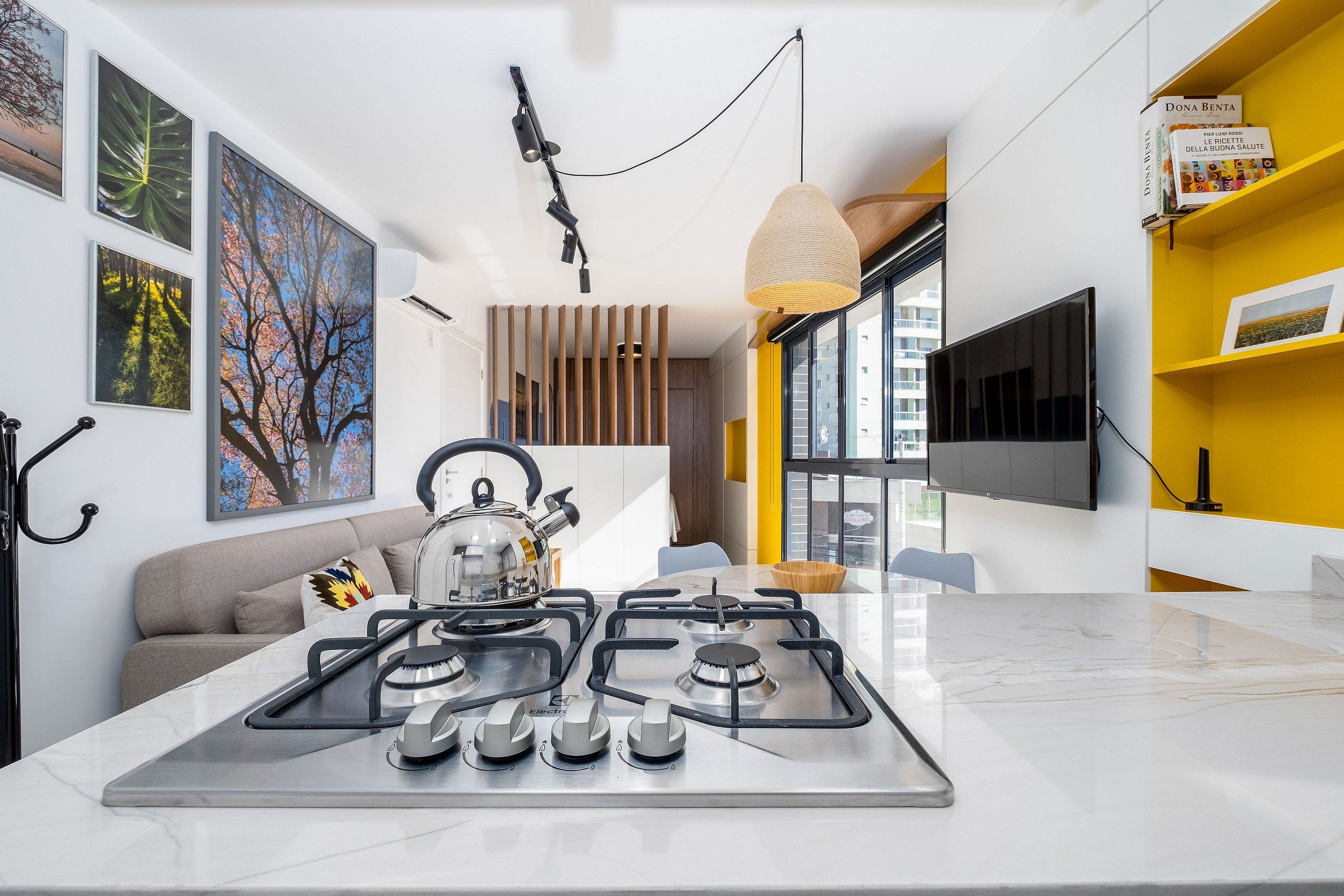 Una cocina moderna con estufa a gas, hervidor y comedor con mesa y sillas.