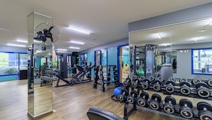 A gym with various exercise equipment, including dumbbells and weight machines. - Flat Vista mar Dentro de Resort de Luxo Sto2206 (Florianópolis)
