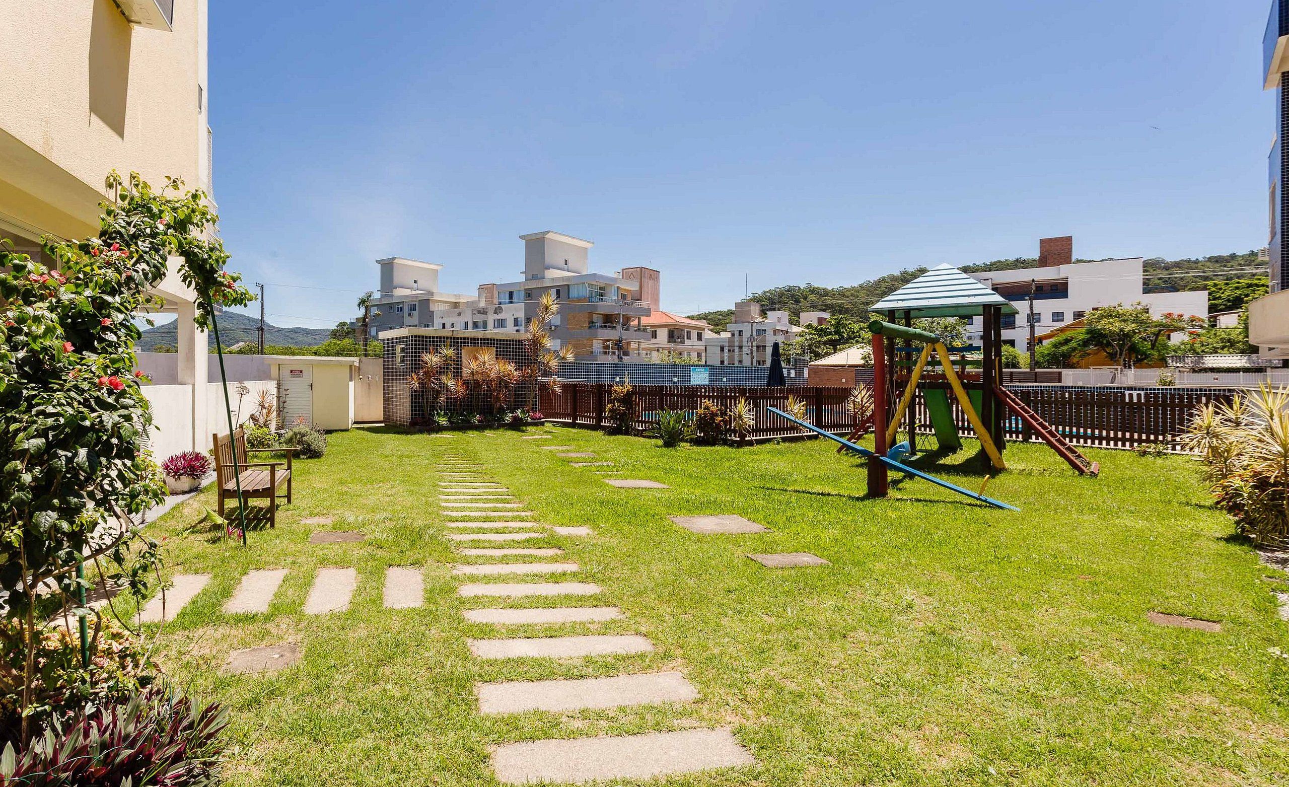 A courtyard with a playground, stone steps, and a view of modern buildings.