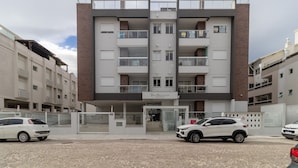 Un edificio de varios pisos con restaurante en la planta baja, con balcones y fachada de ladrillo.