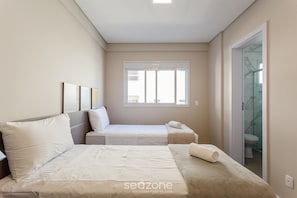 A hotel room with two beds, a window, and a bathroom visible through a glass door. - Building With Swimming Pool in Ingleses Norte - STN (Florianópolis)