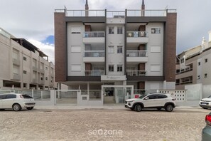 A multi-story building with a restaurant on the ground floor, featuring balconies and a brick facade. - Building With Swimming Pool in Ingleses Norte - STN (Florianópolis)