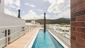 Una piscina en la azotea con vista despejada a una montaña al fondo.