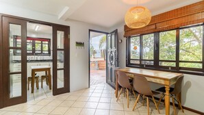 Una cocina con comedor, un ventanal grande y una lámpara colgante.