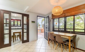 A kitchen with a dining area, a large window, and a hanging light fixture. - House With Pool and Skate Park Stm0500 (Florianópolis)