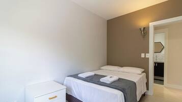 Una habitación de hotel con cama, mesita de noche y armario.
