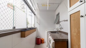 Pieni, käytännöllinen keittiö, jossa on ikkuna, pesuallas ja pieni roskakori.