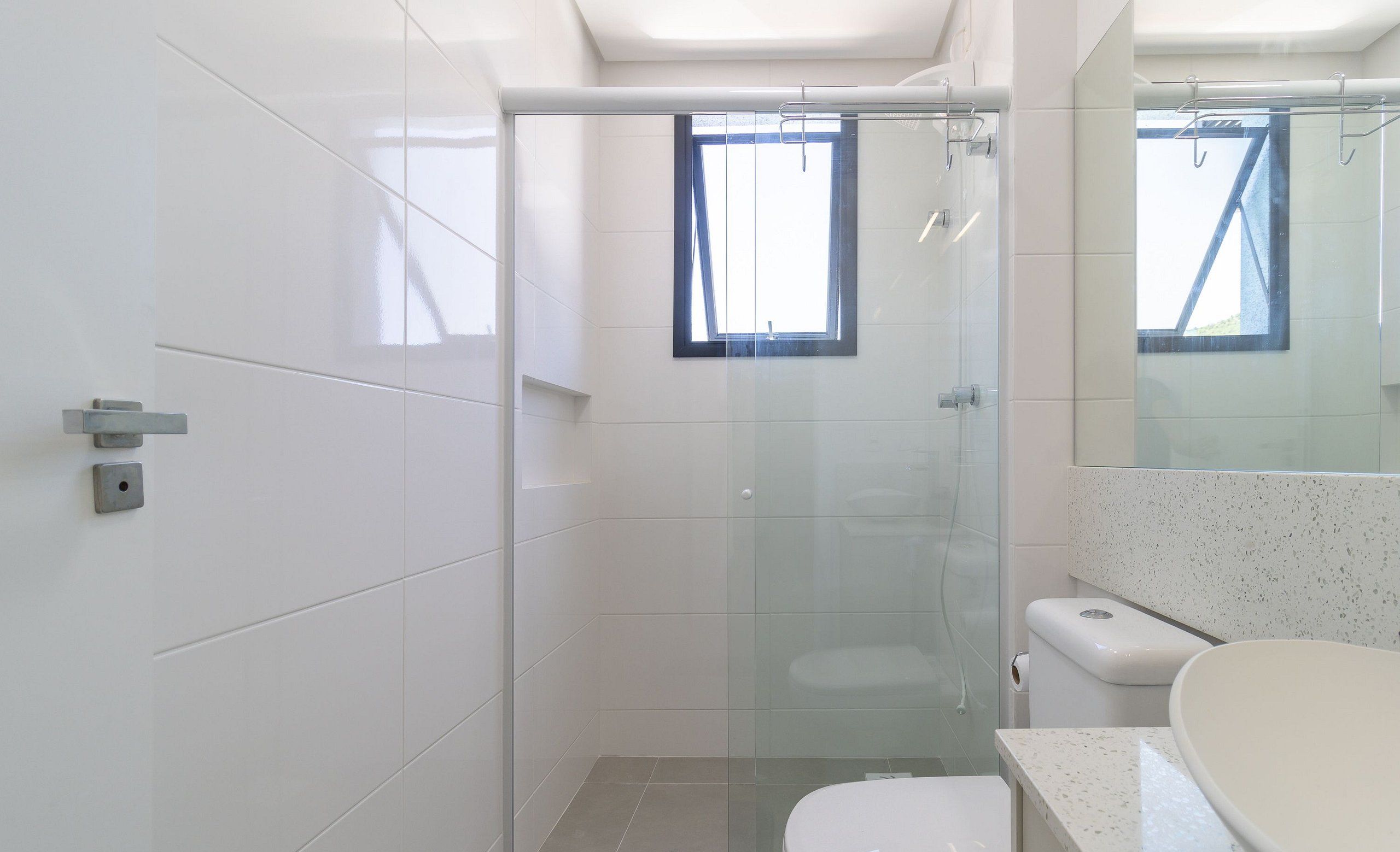 Un baño moderno con ducha de vidrio, inodoro y lavamanos.