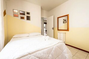 Une chambre d’hôtel avec un lit, une commode et un miroir.
