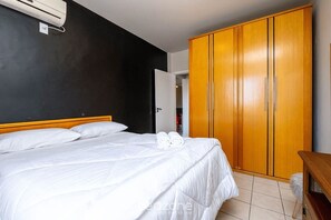 Een hotelkamer met een bed, een kledingkast en een airconditioning.
