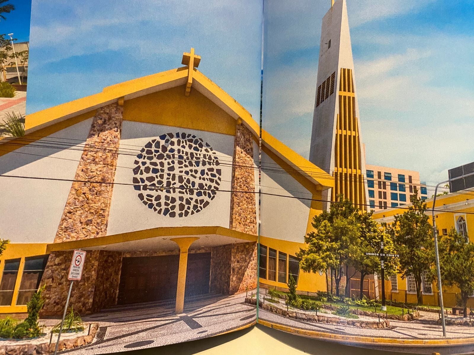 A church with a prominent circular stained glass window, a tall steeple, and a yellow facade.