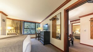 A hotel room with a bed, a desk with a computer, a dresser, and a large window. - Resort at Squaw Creek Tahoe Hyatt 2Bd/2Ba Fireplace Suite (Olympic Valley)