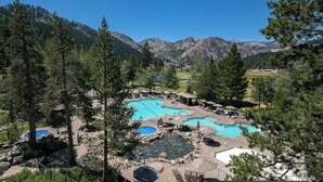 A resort with multiple swimming pools surrounded by trees and mountains. - Resort at Squaw Creek Tahoe Hyatt 2Bd/2Ba Fireplace Suite (Olympic Valley)
