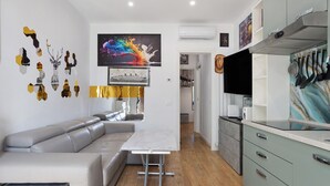 Una cocina moderna con comedor, sofá y televisor.