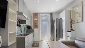 Una cocina moderna con comedor, sofá y televisor de pantalla plana.