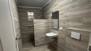 A small bathroom with a toilet, sink, and shower. - 2 persons apartment, Julianadorp (Willemstad)
