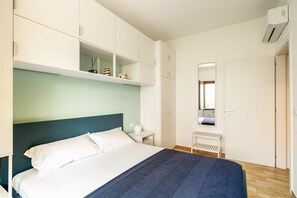 1 dormitorio y tabla de planchar con plancha