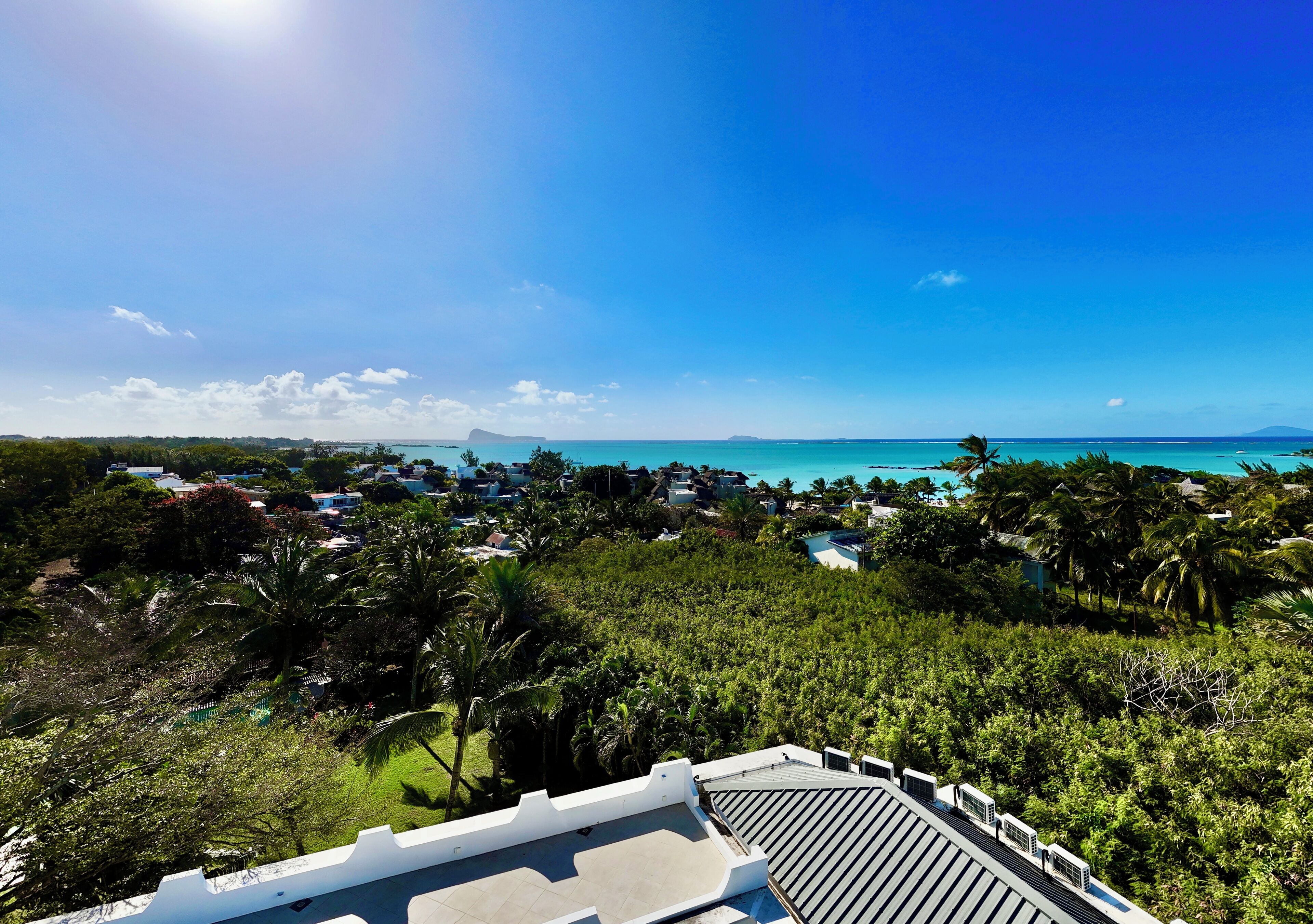A resort with a view of the ocean and a mountainous backdrop.
