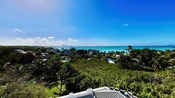 A resort with a view of the ocean and a mountainous backdrop.