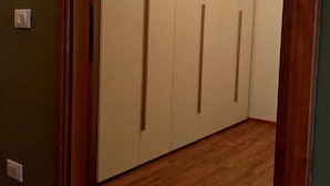 A hallway with wooden flooring and a white door with vertical handles. - Real Italy Retreat: Village, Views & Silence (Cimbergo)