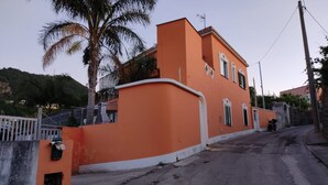 A residential building with a curved wall, a gated entrance, and a street view. - Apartment '2 Vista Mare' with Sea View, Wi-Fi and Air Conditioning (Ischia)