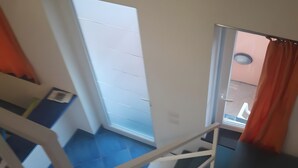 A staircase with a metal handrail, a white door, and a view of a balcony with a railing. - Apartment '2 Vista Mare' with Sea View, Wi-Fi and Air Conditioning (Ischia)