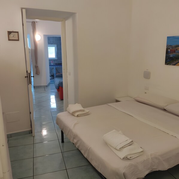 A hotel room with two beds, a bathroom, and a view of the city.
