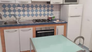 Réfrigérateur, un four, surface de cuisson, vaisselle et ustensiles
