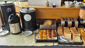 A buffet setup with various food items and kitchen appliances. - Albergue La Pinguina (Mansilla de las Mulas)