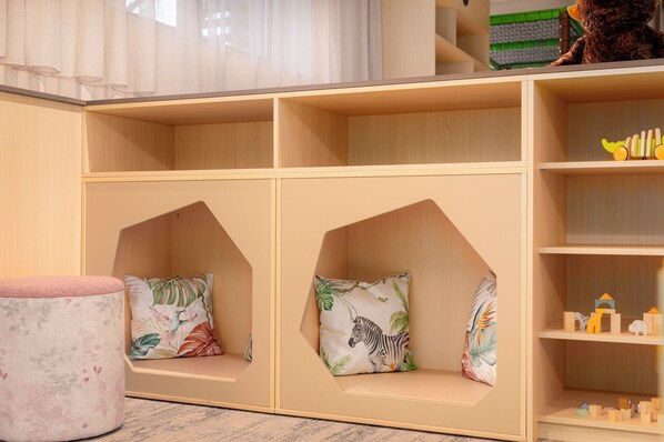 A children's playroom with built-in seating and shelves for toys. - Carpe Solem Kaprun Hotel 4-Sterne-Superior by ALPS RESORTS (Kaprun)