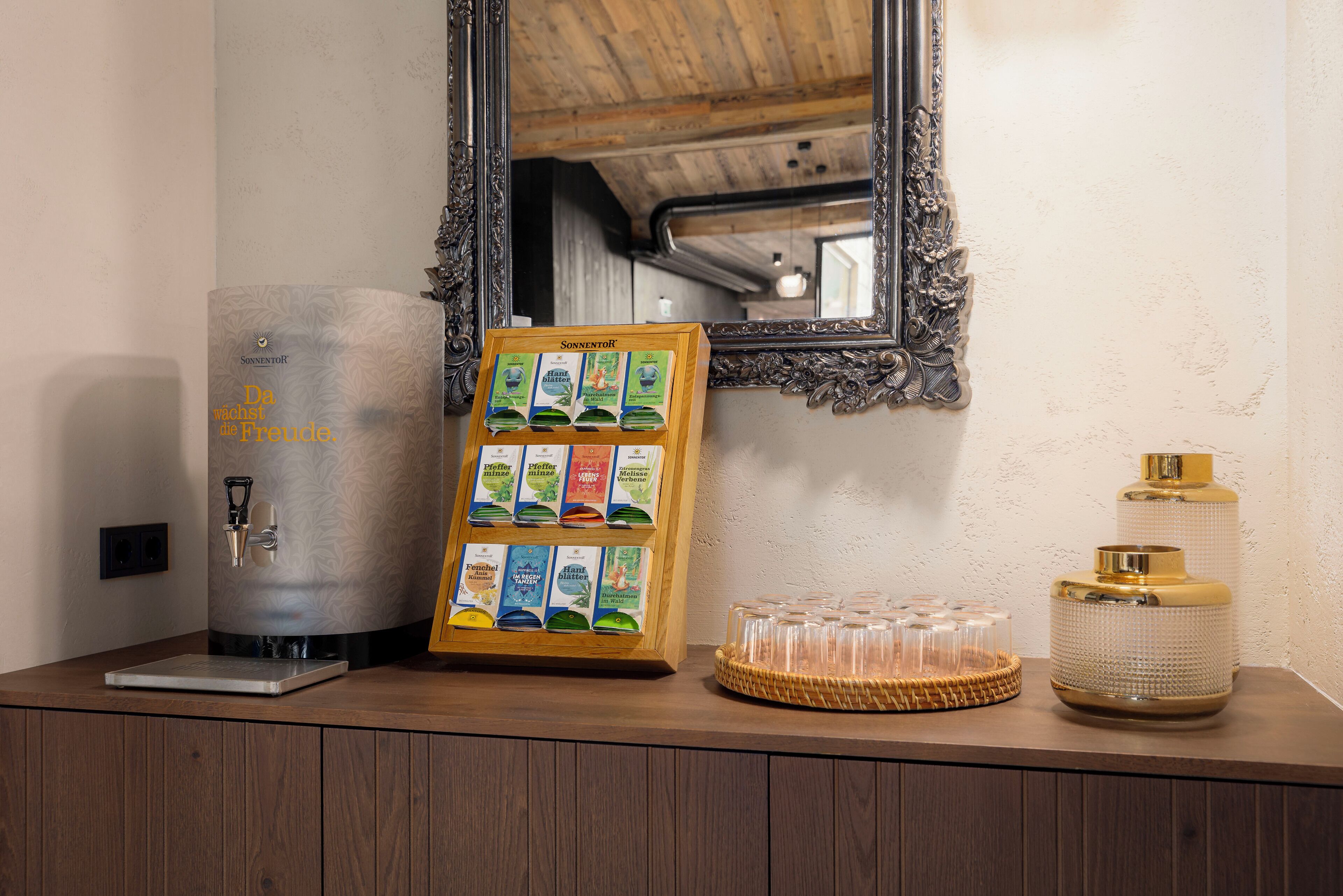 Una estación de café con dispensador de agua, un panel con el menú de café y una jarra de café.