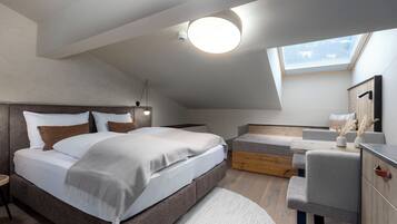 Un dormitorio moderno con techo estilo loft, una cama grande, zona de estar y tragaluz.