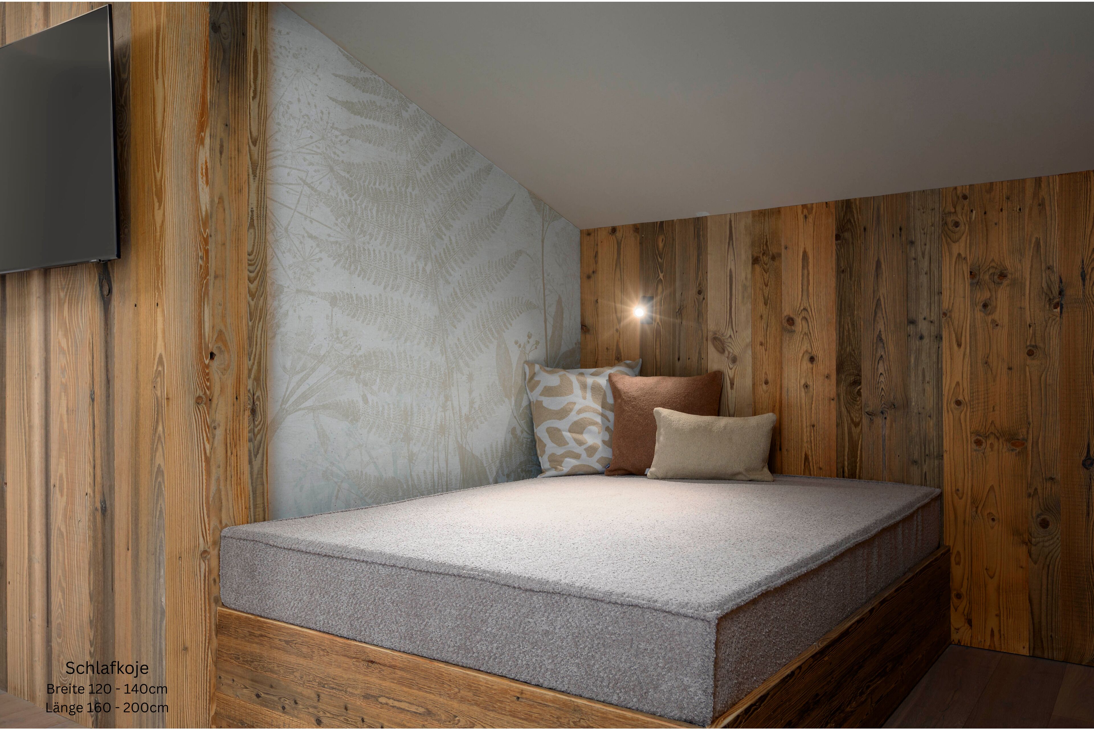Une pièce avec un lit, des murs en bois et un téléviseur fixé au mur.
