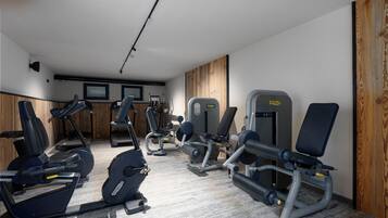 A gym with various exercise equipment including treadmills, elliptical machines, and weight machines.