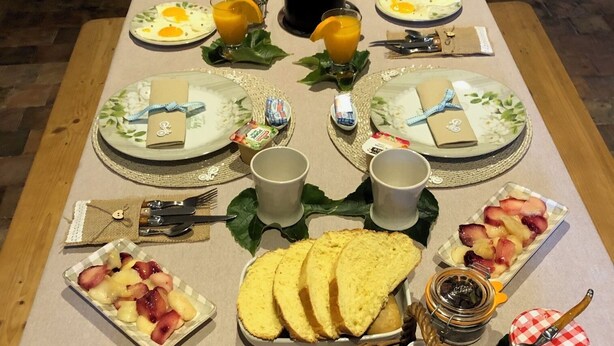 A breakfast table set with plates, cups, and various food items. - Chambre et table d'hôtes LE VERGER near Sancerre, Guédelon, Loire by bike, A77 motorway (Léré)
