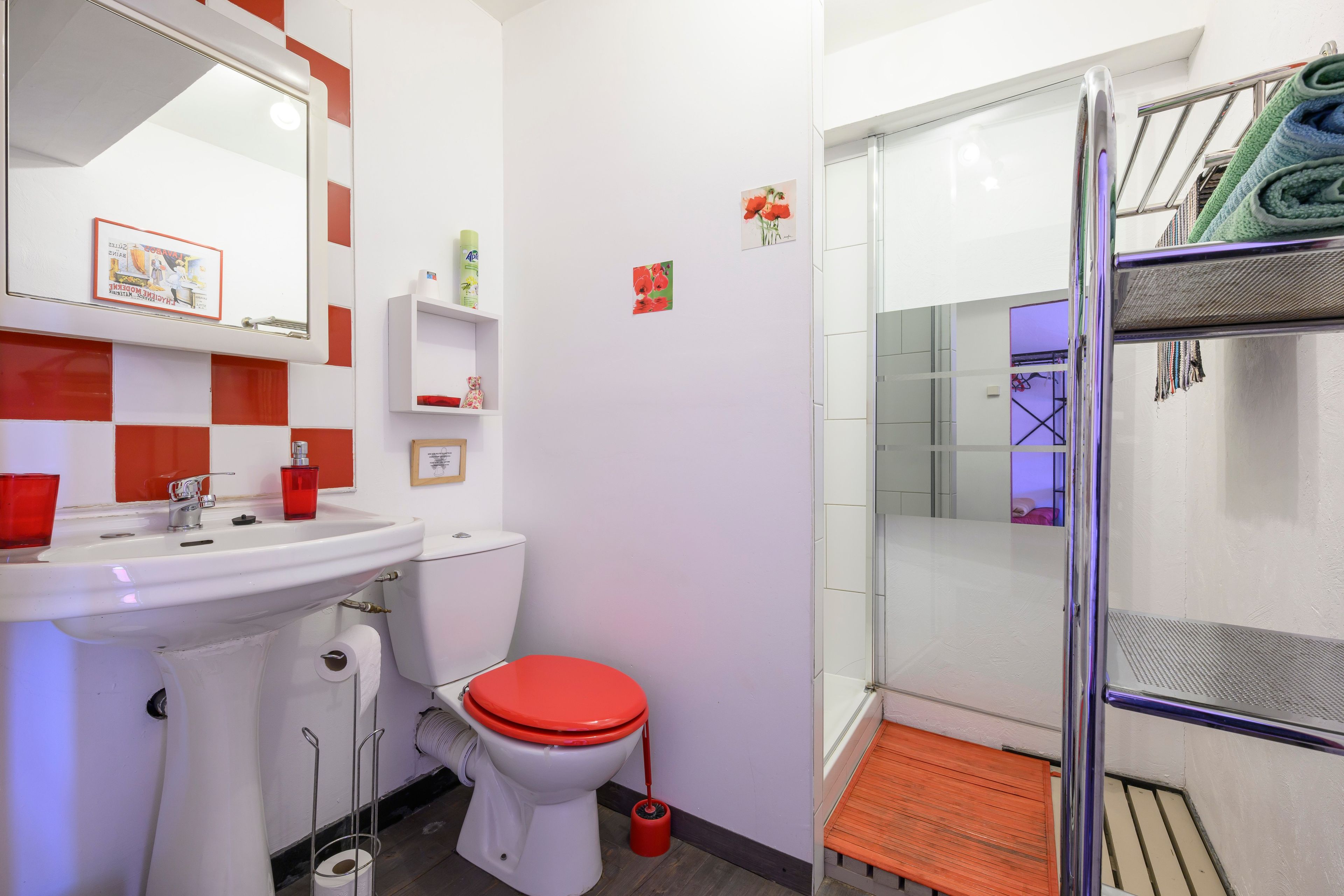 A bathroom with a sink, toilet, and shower area.