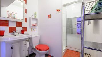 A bathroom with a sink, toilet, and shower area.