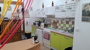 A kitchen with a microwave, coffee maker, and a stove. There are cabinets and a sink.
