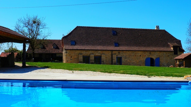 A stone building with a tiled roof, a swimming pool, and a grassy lawn. - Quercy farmhouse (cajarc)