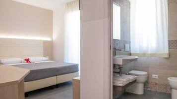 Habitación cuádruple familiar, balcón | Baño | Regadera, secadora de cabello, toallas, jabón