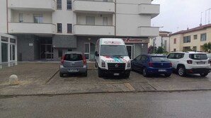 A parking area with a white van and several cars parked in front of a building with a sign reading "Il Panettieri". - B&B Stern (Porto San Giorgio)