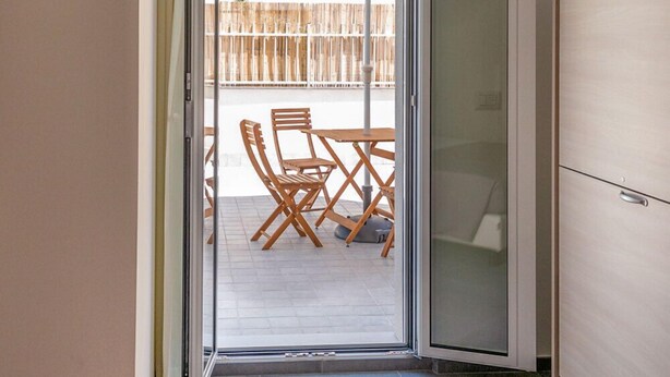 A room with a sliding glass door leading to an outdoor patio area with a table and chairs. - B&B Stern (Porto San Giorgio)