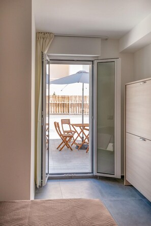 A room with a sliding glass door leading to an outdoor patio area with a table and chairs. - B&B Stern (Porto San Giorgio)