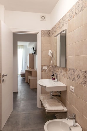 Comfort tweepersoonskamer | Badkamer | Een douche, een haardroger, handdoeken, zeep